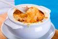 French onion gratin soup in a white pot, close-up Royalty Free Stock Photo