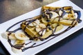 French pancake with banana and chocolate on the white plate