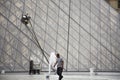 French people cleaner use automatic machine cleaning glass of Louvre Pyramid