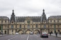 French people driving and biking with travelers walking and traffic road at front of Musee du Louvre