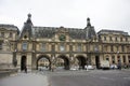 French people driving and biking with travelers walking and traffic road at front of Musee du Louvre