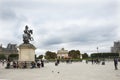 French people and foreigner travelers sitting and take photo with King Louis XIV Statue