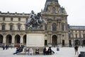 French people and foreigner travelers sitting and take photo with King Louis XIV Statue