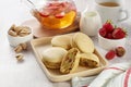 French strawberry pistachio macaron with berries tea. Afternoon tea still life