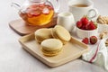 French strawberry pistachio macaron with berries tea. Afternoon tea still life