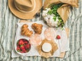 Flat-lay of glasses of rose wine, strawberries, croissants, brie cheese