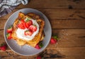 French toast with fresh strawberries, coconut shreds and honey, on wooden background, top view, text space, copy space