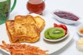 French toasts cooked and served with fruit, bacon, honey, jam and coffee Royalty Free Stock Photo