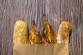 French traditional baguettes in paper bags on wooden table background