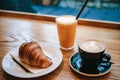 French traditional croissant dessert next to coffee cappuccino and orange juice in a cafe for breakfast.