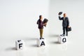 frequently asked questions abbreviation with miniature businessmen figurines having a gathering Royalty Free Stock Photo