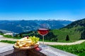 fresch tirol cheese with wine and grapes over mountain landscape