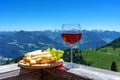 fresch tirol cheese with wine and grapes over mountain landscape