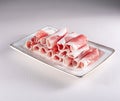 fresh and aesthethic bacon rolls on a white plate. View from above. Chinese cuisine, ingredient for hotpot