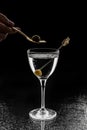 Fresh alcoholic cocktail with vodka and olive in wineglass on black background. Summer cold drink and cocktail Royalty Free Stock Photo