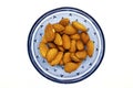 Fresh Almonds nuts on a blue glass bowl in a white isolated background Royalty Free Stock Photo