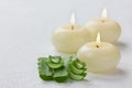 Fresh aloe vera leaf and burning candles on white surface Royalty Free Stock Photo