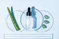 Fresh aloe vera leaves and slices, cosmetic serum with aloe vera extract in glass bottle with pipette in petri dishes on white