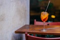 Fresh Aperol spirits coccktail, on wooden table in restaurant. Horizontal shot of summer beverage. Orange liquid with ice. Apereti Royalty Free Stock Photo