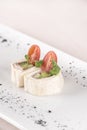 Fresh appetizer with pita bread roll,  with cream cheese,  ham and green vegetables,  decorated with tomato and green leaf, Royalty Free Stock Photo