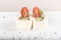 Fresh appetizer with pita bread roll,  with cream cheese,  ham and green vegetables,  decorated with tomato and green leaf, Royalty Free Stock Photo