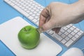 Fresh apple as piggy bank and hand with coin. Concept in style: Investing in computer technology. Royalty Free Stock Photo