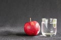 Fresh apple with glass of clean drinking water over gray background Royalty Free Stock Photo