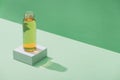 Fresh apple juice on white cube on green and turquoise background