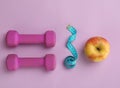 Fresh apple, measuring tape and dumbbells