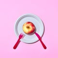 Fresh apple on a plate served with plastic knife and fork Royalty Free Stock Photo