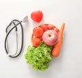 Fresh apple, tomato, carrot and lettuce with stethoscope and heart concept of natural food diet nutrition and healthy lifestyle. Royalty Free Stock Photo