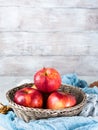 Fresh apples in basket on wooden background. Vertical Royalty Free Stock Photo