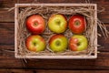 Fresh apples in box on wooden table close-up
