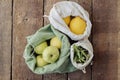 Fresh apples, lemons, arugula in eco cotton bags on rustic wood. Zero waste, top view. Sustainable Royalty Free Stock Photo