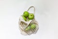 Fresh apples in a string bag, eco-friendly product on a light background. Royalty Free Stock Photo