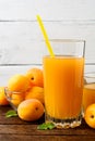 Fresh apricot juice and apricots on wooden table. Royalty Free Stock Photo