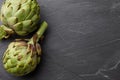 Fresh artichokes close up on textured stone background