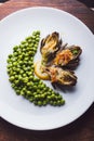 Fresh artichokes with parsley and young beans in a baking pan, parmesan in background. Royalty Free Stock Photo