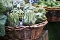 Fresh artichokes in a wicker basket on a brick floor in a vegetable garden Royalty Free Stock Photo