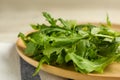 Fresh arugula leaves on wooden plate, closeup Royalty Free Stock Photo