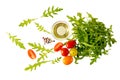 Fresh arugula salad with cherry tomatoes, olive oil bowl and spices flying Royalty Free Stock Photo