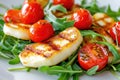 Fresh arugula salad with grilled halloumi and cherry tomatoes on a light textured background Royalty Free Stock Photo