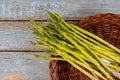 Fresh asparagus in brown basket on wood table Royalty Free Stock Photo
