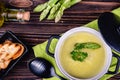 Fresh asparagus creamy soup and ingredients on a wooden table. Royalty Free Stock Photo