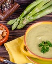 Fresh asparagus creamy soup and ingredients on a wooden table. Royalty Free Stock Photo