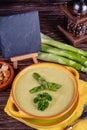 Fresh asparagus creamy soup and ingredients on a wooden table. Royalty Free Stock Photo