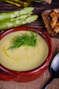 Fresh asparagus creamy soup and ingredients on a wooden table. Royalty Free Stock Photo