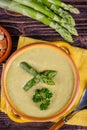 Fresh asparagus creamy soup and ingredients on a wooden table. Royalty Free Stock Photo