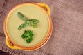 Fresh asparagus creamy soup and ingredients on a wooden table. Royalty Free Stock Photo