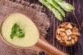 Fresh asparagus creamy soup and ingredients on a wooden table. Royalty Free Stock Photo